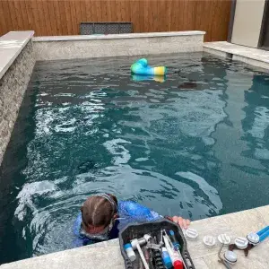 Pool leak detection technician using electronic listening equipment to find a leak from the pool deck